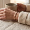 Bracelet en cuivre à maillons, lisse et rosé, fermoir clip, porté au poignet