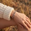 Bracelet en cuivre à maillons ronds sertis de strass, porté au poignet