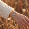 Bracelet en cuivre tressé, torsade en épi argentée, porté au poignet