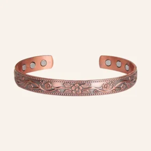 Jonc ouvert en cuivre patiné gravé de fleurs et de rinceaux, six pastilles rondes à l'intérieur