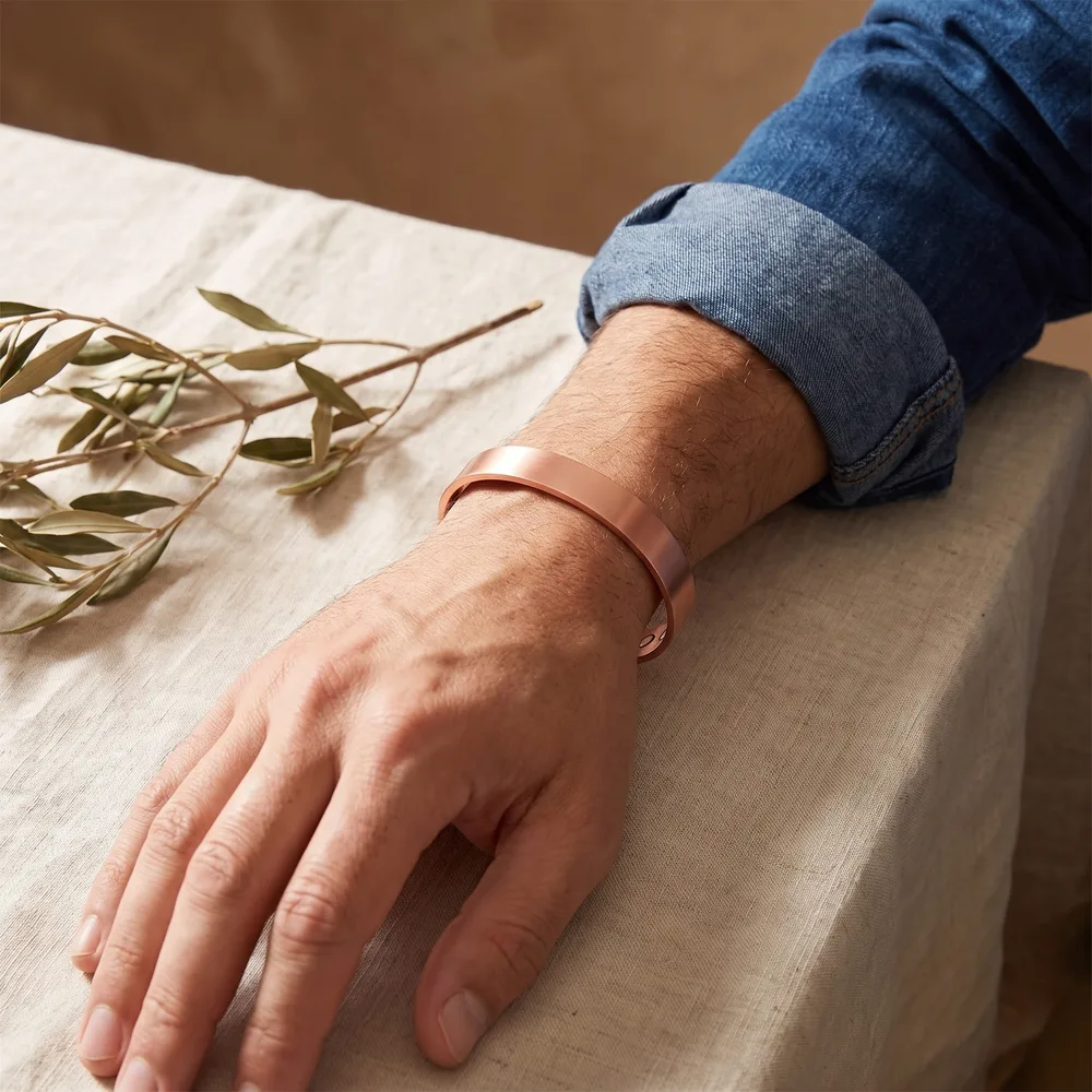 Jonc en cuivre lisse satiné, large et minimaliste, porté au poignet