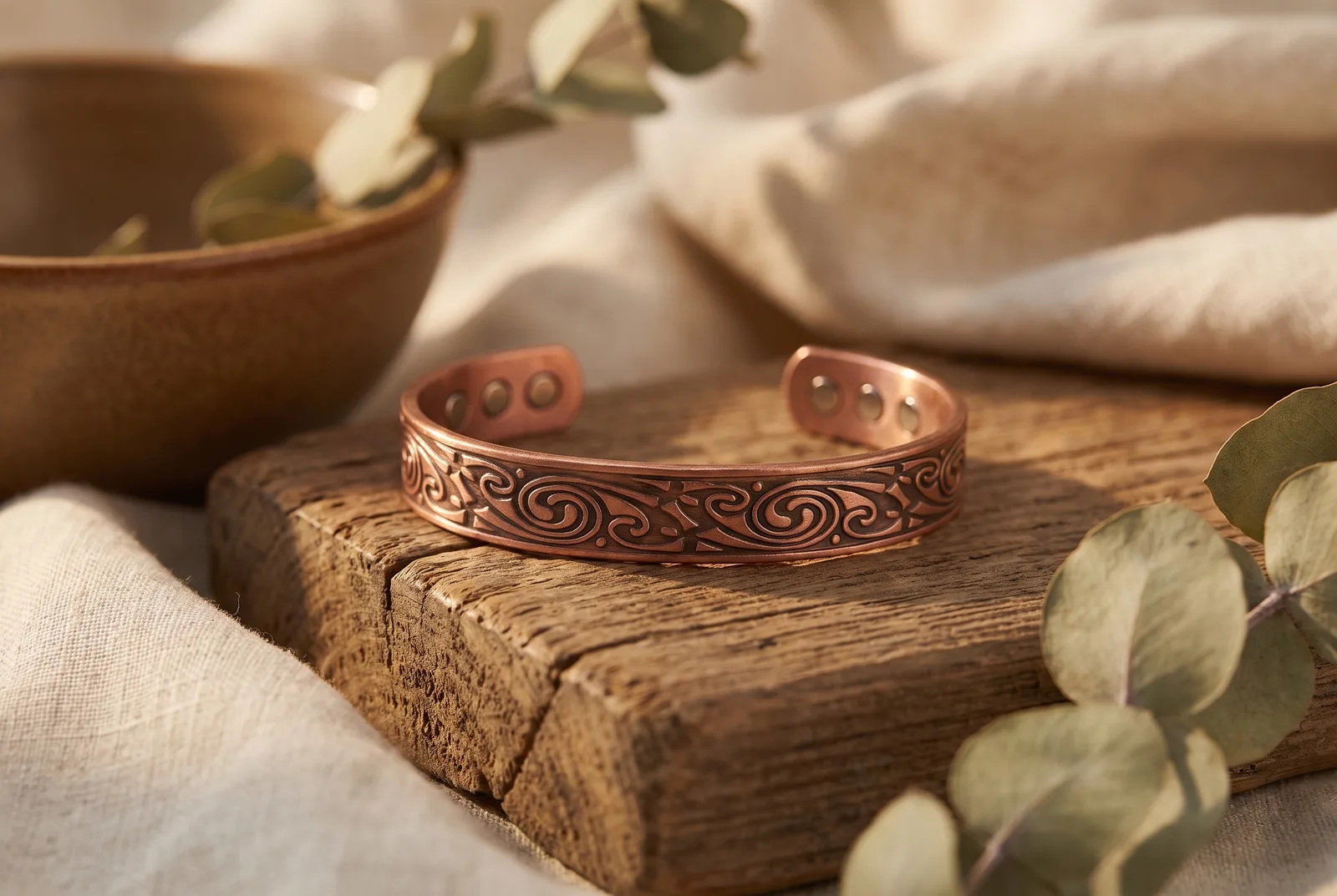 Jonc en cuivre patiné aux spirales celtiques posé sur du bois ancien